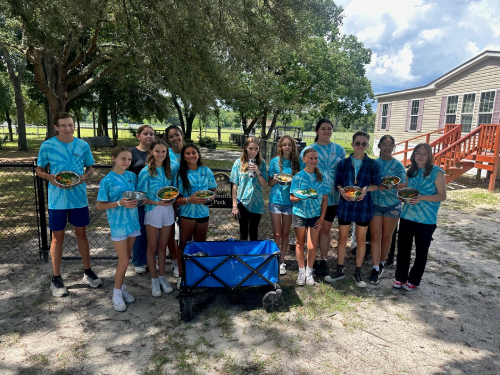 Group of youth volunteers by Angel's Memorial Park with pet bowls