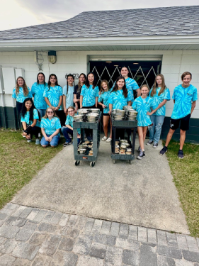 Group of youth council volunteers with bowls by the building - Photo 2 of 2