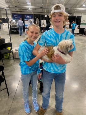 Two youth council volunteers with a small dog