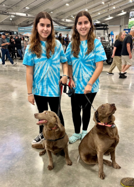 Twin youth council volunteers with two dogs