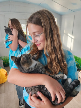 Youth volunteer cradling a cat